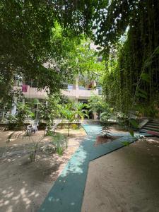a garden with a green pathway with benches and trees at Monkey villa in Hikkaduwa