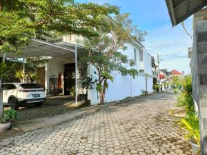 une rue avec une voiture garée à côté d'un bâtiment dans l'établissement Serene Home, à Demangan