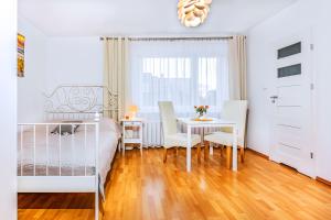 a bedroom with a bed and a table and chairs at Willa Muszelka Przy Morzu in Jastarnia +27 photos