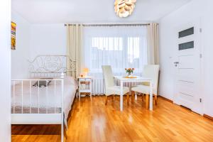 a bedroom with a bed and a table and chairs at Willa Muszelka Przy Morzu in Jastarnia