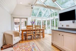 een serre met een tafel en stoelen en een eetkamer bij The Little House in Thatcham