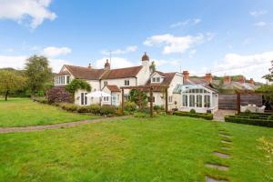 una gran casa blanca con un patio verde en The Little House en Thatcham