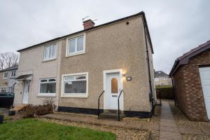 a brick house with a white door at 2Bed-Free Parking-EV Charger in Wishaw