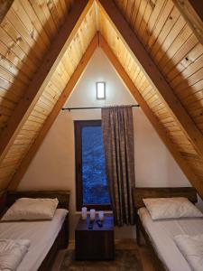a attic bedroom with two beds and a window at Vikendica IVA in Pale