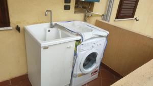 a washing machine and a sink in a bathroom at Feudo 62 in Reggio di Calabria