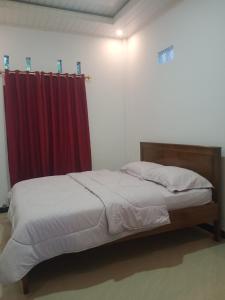 1 dormitorio con 1 cama con cortina roja en THE TWINS HOMESTAY, en Rantepao