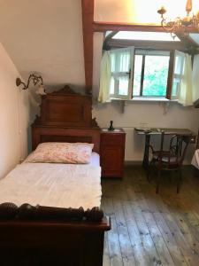 a bedroom with a bed and a table and a window at etno kuća Đeram in Mokrin