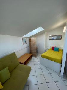 a bedroom with a bed and a couch in a room at 3CONV48- Charmant T2 avec vue imprenable en face plage Collioure in Collioure