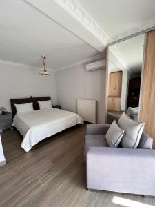 een slaapkamer met een bed en een bank bij KONTIS' Deluxe furnished apartment in Loutraki