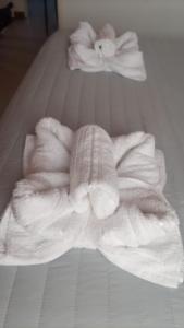 uma pilha de toalhas brancas numa cama em Hospedaje de Ensueño SMA em San Martín de los Andes