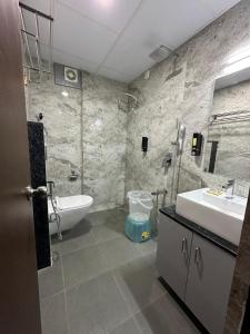 a bathroom with a tub and a sink and a toilet at Hotel Banyan Tree Yeshwanthpur in Bangalore