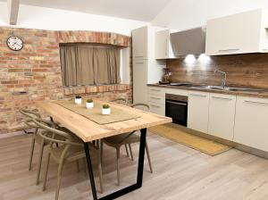 a kitchen with a wooden table and some chairs at Simona Apartments in Portocannone