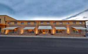 a large building with tables and chairs in front of it at Simona Apartments in Portocannone