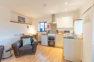 a kitchen with a couch and a chair in a room at Tryfan Holiday Cottage in Llanfairpwllgwyngyll