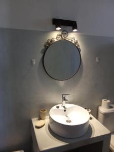 a bathroom with a sink and a mirror on the wall at kominoshouses in Skala