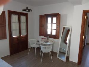a room with a table and chairs and a mirror at kominoshouses in Skala +9 photos
