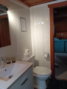 a bathroom with a white toilet and a sink at Harmony House in Salvan