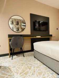 1 dormitorio con cama, espejo y silla en SKY PARK HOTEL, en Dubái