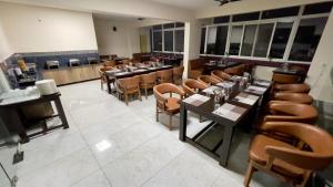 Hotel Banyan Tree Yeshwanthpur في بانغالور: غرفة طعام مع طاولات وكراسي في مطعم
