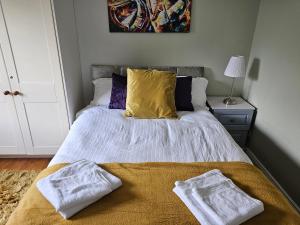 a bedroom with a bed with two towels on it at Oak House Laois B&B in Portarlington