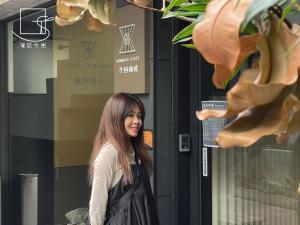 a woman standing in front of a building at Konkai Inn in Tainan