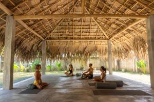 a group of women sitting in a pavilion doing yoga at Lotus Surf And Wellness in Ahangama