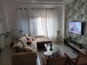 uma sala de estar com um sofá e uma televisão em ADB Properties em Ogbojo