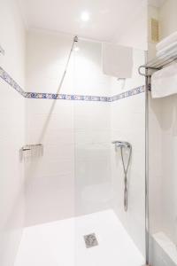 La salle de bains est pourvue d'une douche avec une porte en verre. dans l'établissement Hotel Alkazar, à Valence