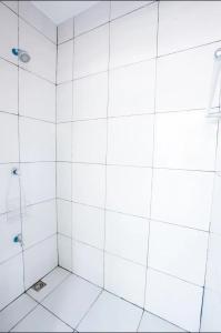 y baño con ducha de azulejos blancos. en Villa Gumamela Siargao, en Catangnan