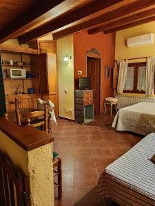 a bedroom with two beds and a television in a room at Turismo Rural Calaliu in Peratallada
