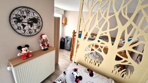 um quarto com uma cama com um mural de árvore na parede em Le Debussy 5 personnes, lit bébé, balcon, parking privé gratuit em Chessy