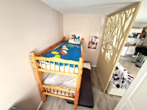 a small bedroom with a wooden bunk bed at Le Debussy 5 personnes, lit bébé, balcon, parking privé gratuit in Chessy