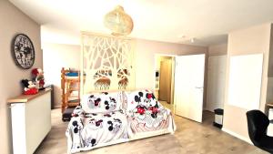 a bedroom with a bed and a chair with pillows at Le Debussy 5 personnes, lit bébé, balcon, parking privé gratuit in Chessy