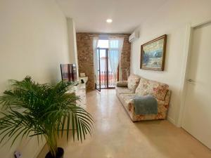 ein Wohnzimmer mit einem Sofa und einer Pflanze in der Unterkunft Apartamento en Almenara a 4 KM de la playa in Almenara