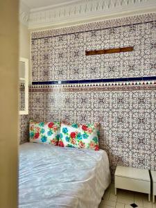 Un dormitorio con una cama con una pared de acento floral en Riad Le Palais en Rabat