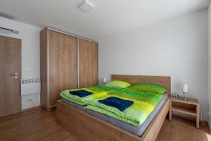 Schlafzimmer mit einem großen Bett mit einem Kopfteil aus Holz in der Unterkunft Apartmány Pustiměř in Pustiměř