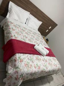 a bed with a floral blanket and pillows on it at Itaverá Master Hotel in Presidente Prudente