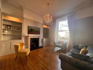 a living room with a couch and a fireplace at No2 Clarence grade II Regency townhouse short walk to racecourse and town centre in Cheltenham