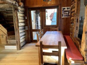 een houten tafel en stoelen in een kamer met een deur bij Magnificent spacious 4 bedroom mountain chalet with spa in Antey-Saint-André