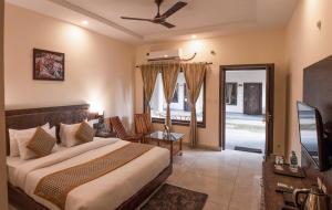 a bedroom with a large bed and a television at VOW HOTELS AND RESORTS in Belparāo