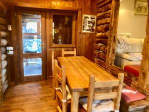 een eetkamer met een houten tafel in een hut bij Magnificent spacious 4 bedroom mountain chalet with spa in Antey-Saint-André