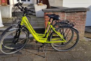 uma bicicleta amarela estacionada ao lado de uma parede de tijolos em Adagio Brugge em Bruges