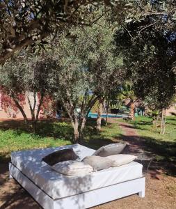 Una cama con almohadas en un parque en Manzal Lahbab (Pavillons, Bungalows, Piscine et Jardins), en Marrakech