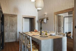a kitchen with a table and chairs in a room at VILLA OIA 1880 in Oia