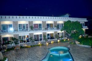 a hotel with a swimming pool in front of a building at VOW HOTELS AND RESORTS in Belparāo