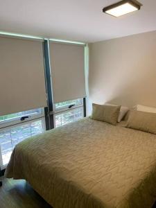 a bedroom with a large bed and two windows at Lujo, PS5 cerca de las mejores Bodegas + desayuno in Ciudad Lujan de Cuyo