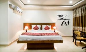 a bedroom with a large bed and a chair at Rainbow International Hotel Airport Zone Shamshabad in Shamshabad