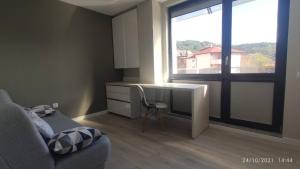 a living room with a desk and a window at Central, brand new apart with parking in Blagoevgrad