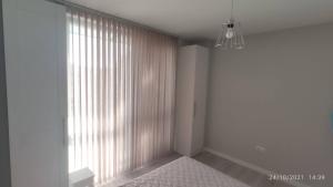 a white room with a large window and a chandelier at Central, brand new apart with parking in Blagoevgrad