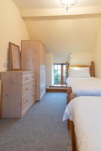 サンヴァイルプスグィンガスにあるYr Eifl Cottageのベッドルーム1室(ベッド2台、ドレッサー、窓付)